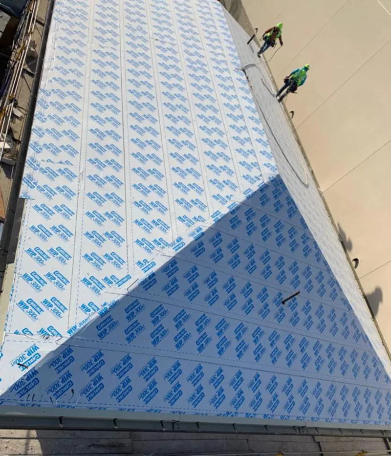 Professional roofers installing underlayment on a metal roof in Florida City